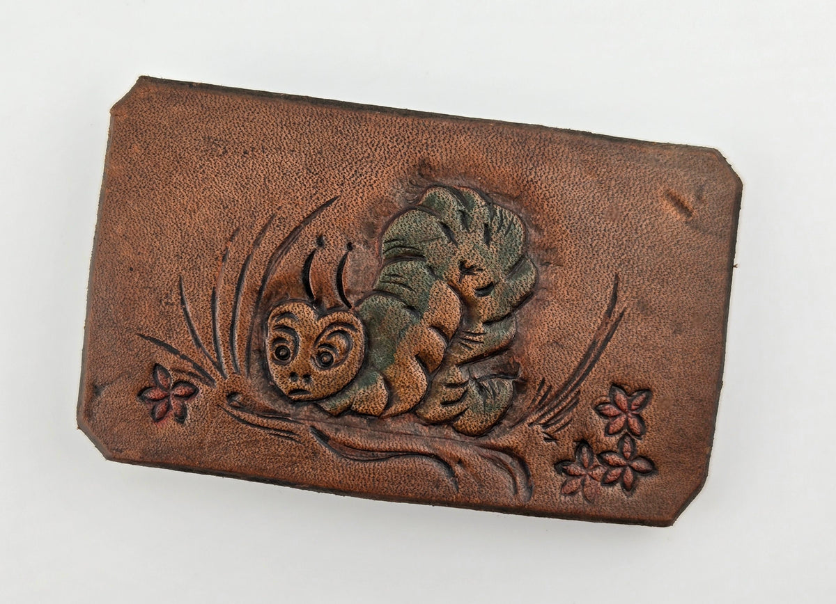 Front of the Hand Tooled Leather Vintage Belt Buckle — Green Squirrel & Red Flowers, showing a bushy-tailed squirrel in green-tinted tooling with small red flowers on a warm tan-brown leather face.