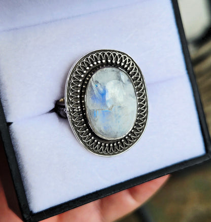 Silver ring with a large gemstone in a display box